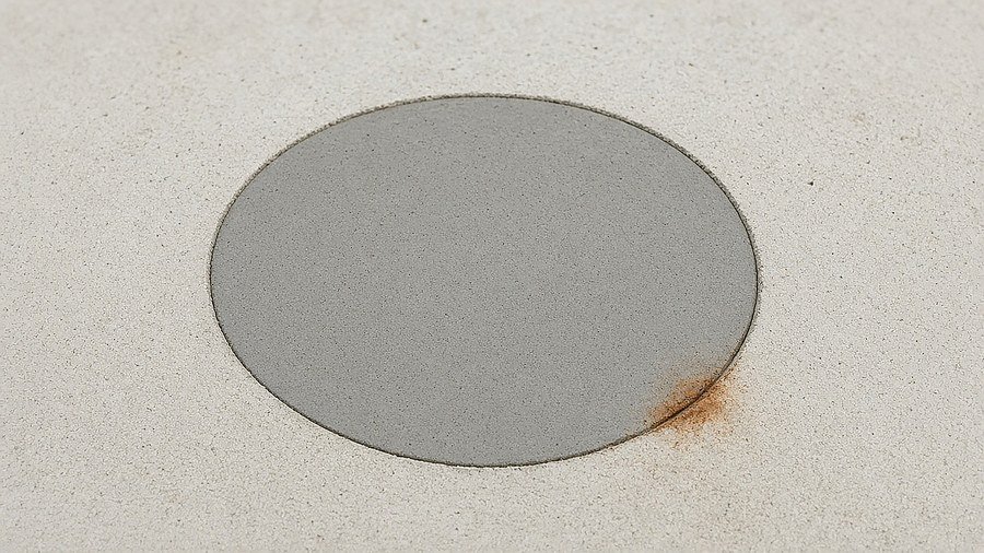 Rust stain and neat patch on pale concrete